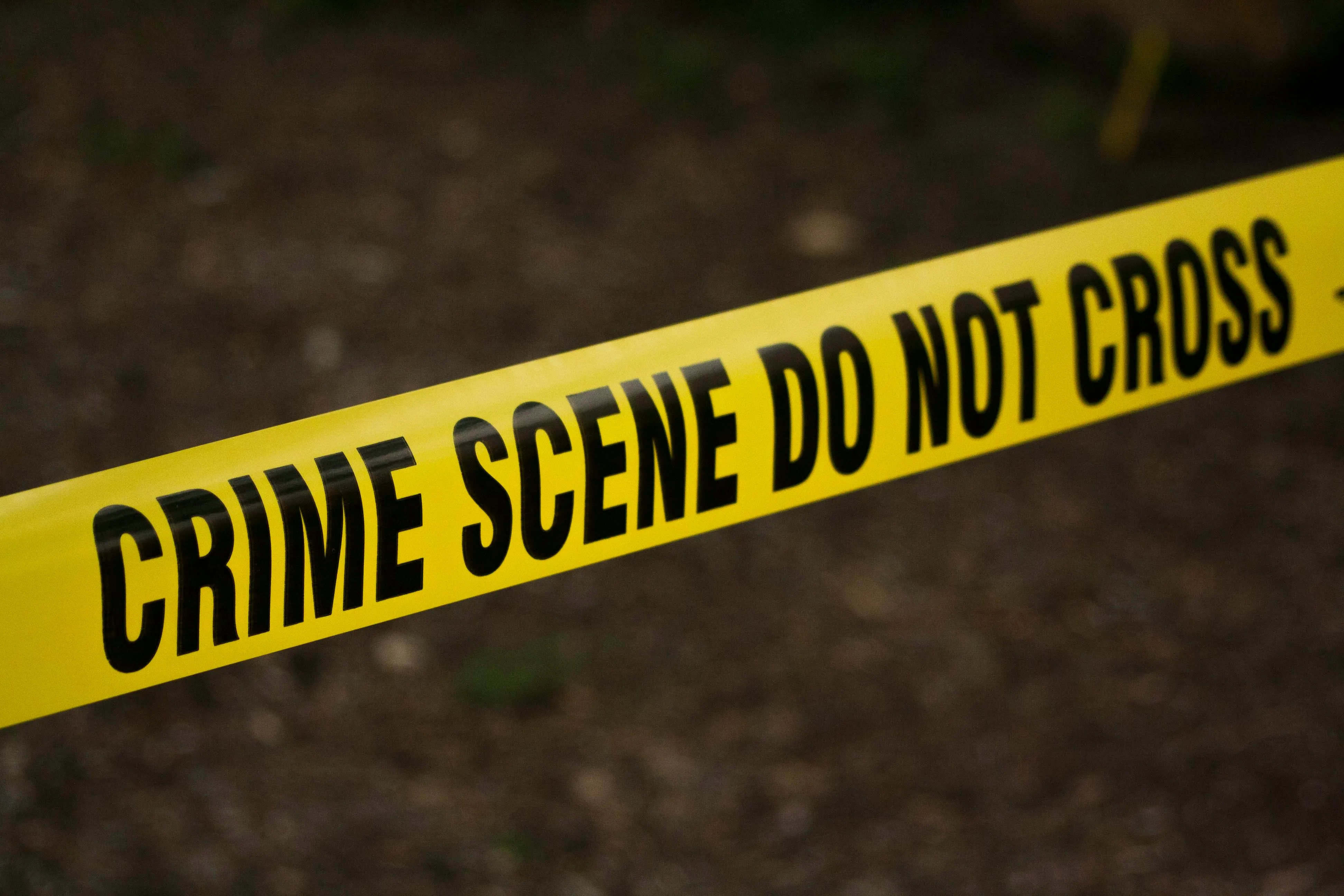 Yellow police tape cordoning off an out-of-shot crime scene